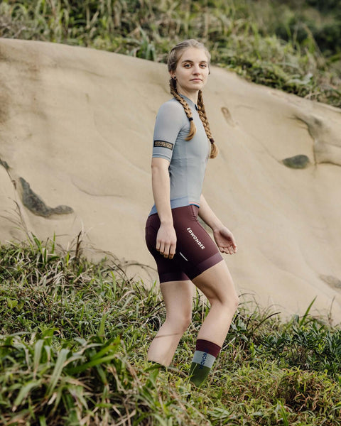 Woman wearing Women's EdW Edition Jersey in Steel Gray, showcasing a minimalist design and race fit in a natural setting.